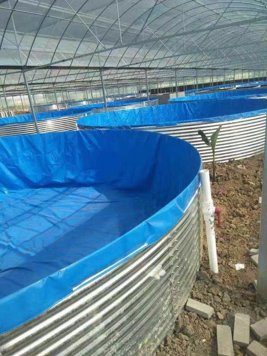 Outdoor setup of cylindrical steel water tanks on dirt ground.