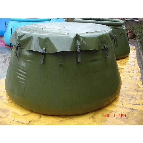 Large green inflatable water storage bladder with a protective cover and straps, placed on a yellow surface, ideal for durable emergency water storage or military use, with another bladder in the background.