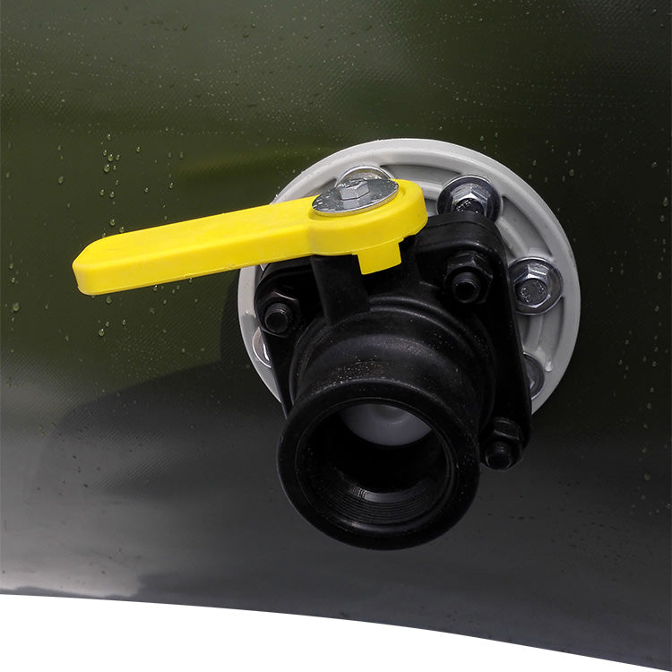 A close-up view of a black valve with a yellow handle, attached to a white fitting on a green surface, likely part of a water tank. The valve has bolts securing it in place, and small water droplets are visible on the background.