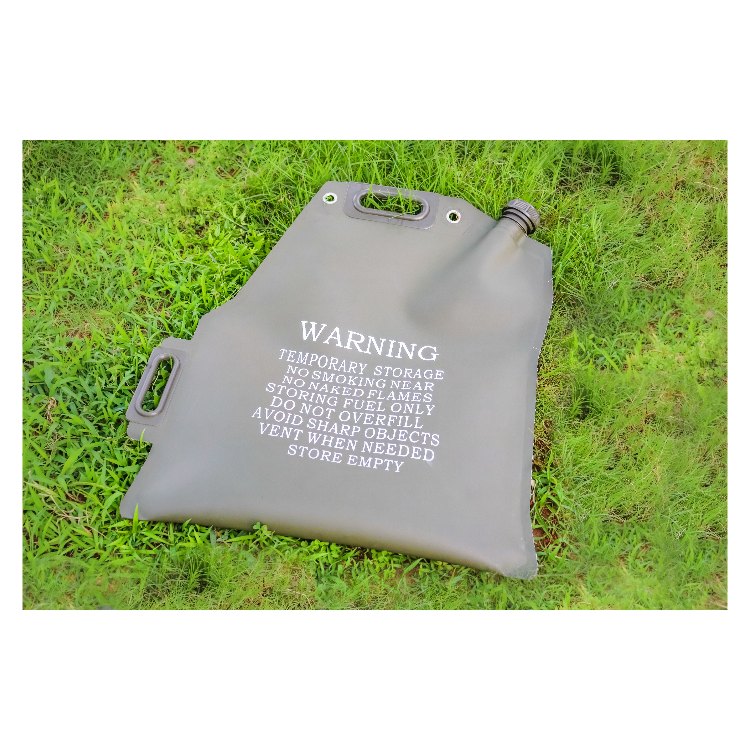 A small white airplane with a red nose is parked on a grassy field, with a person in a plaid shirt and red cap standing near the cockpit refueling the plane. The background features rolling green hills dotted with trees under a clear sky, and various equipment is scattered around the aircraft.