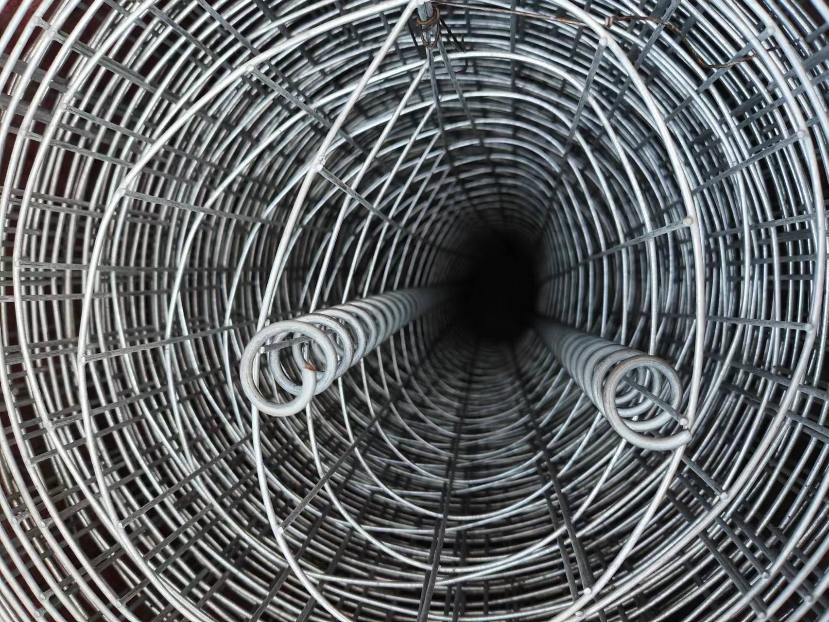 A rolled steel wire mesh with a spiral pattern, typically used for construction, fencing, or industrial applications.