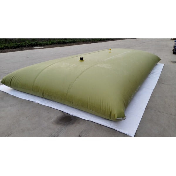 light-colored, inflated flexible water storage tanks of varying sizes sit on a concrete surface, with a truck partially visible in the background.